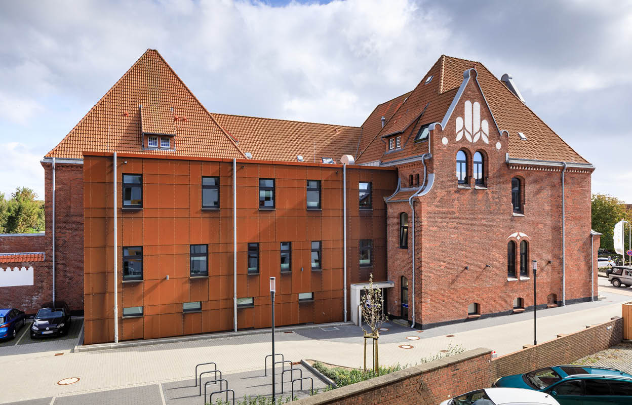 Polizeistation Sylt. Außenansicht mit Altbau und Anbau. 